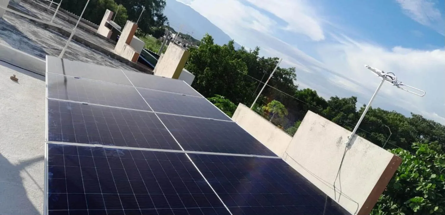 Paneles solares en una azotea de Colima rodeada de árboles y cerros