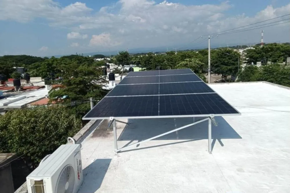 Cuatro paneles solares de 630 W sobre una azotea blanca en Palo Alto, Villa de Álvarez, junto a la condensadora de un minisplit